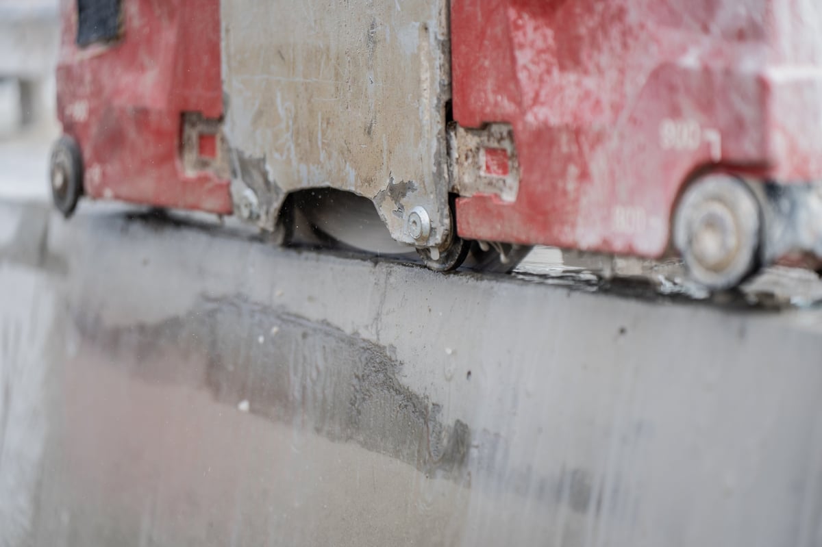 Concrete wall saw cutting reinforced slab edge showing precision demolition work